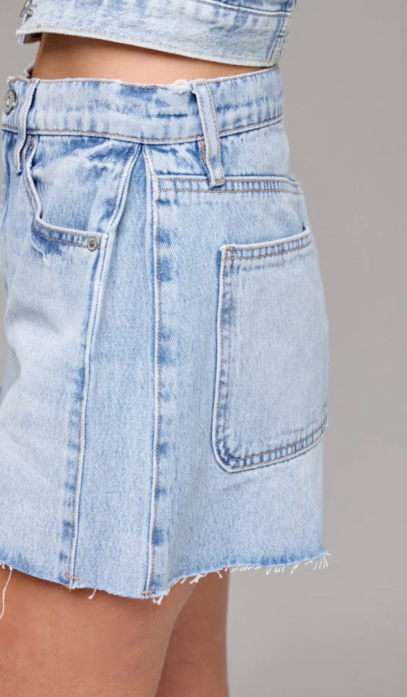 Light blue denim skirt on a neutral background