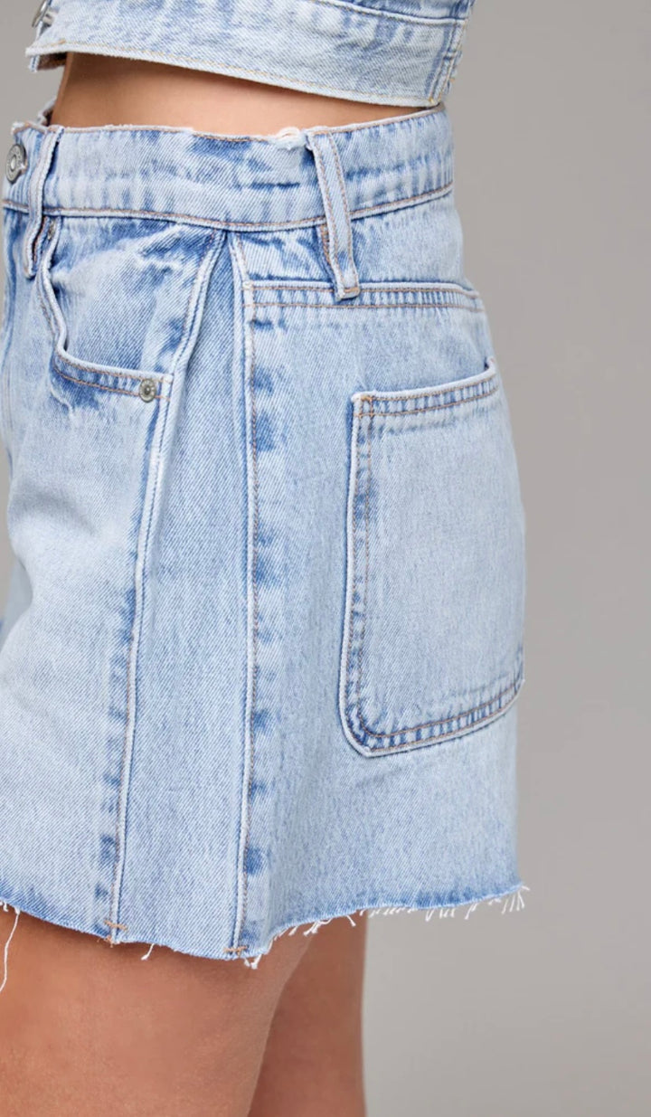 Light blue denim skirt on a neutral background