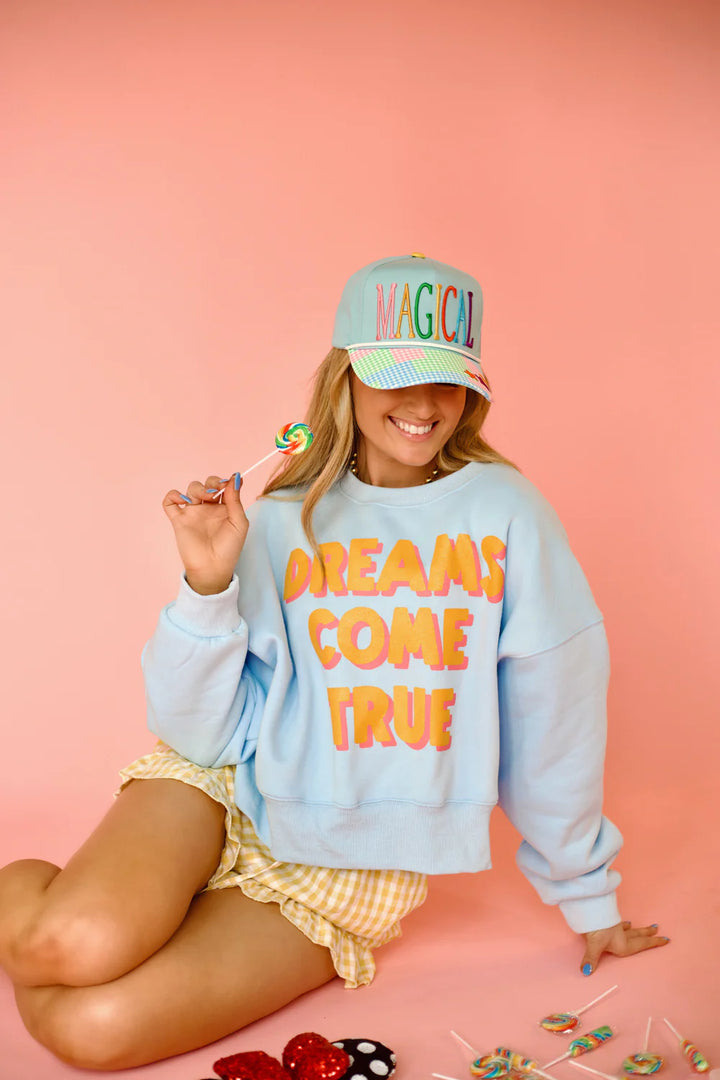 Woman wearing light blue sweatshirt with &