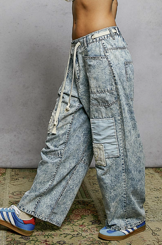 Person wearing acid wash jeans on plain background