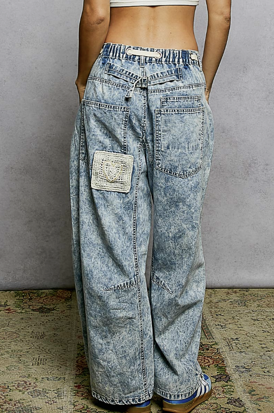 Person wearing acid-wash jeans with a plain background