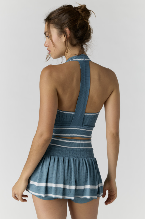 Woman wearing a blue dress with a white stripe on a plain background
