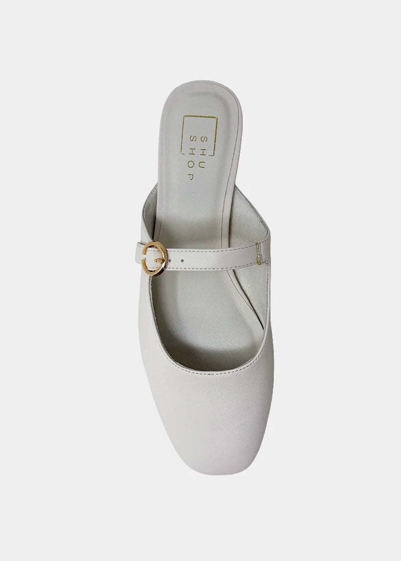 White sandal with a gold buckle on a white background