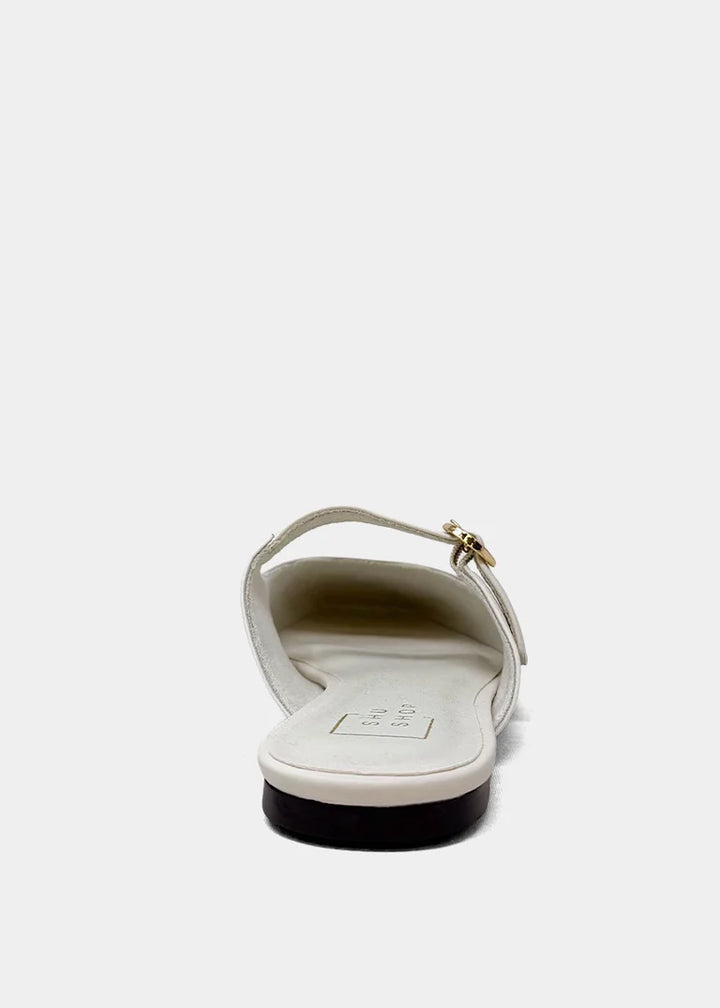 White sandal with a gold buckle on a white background