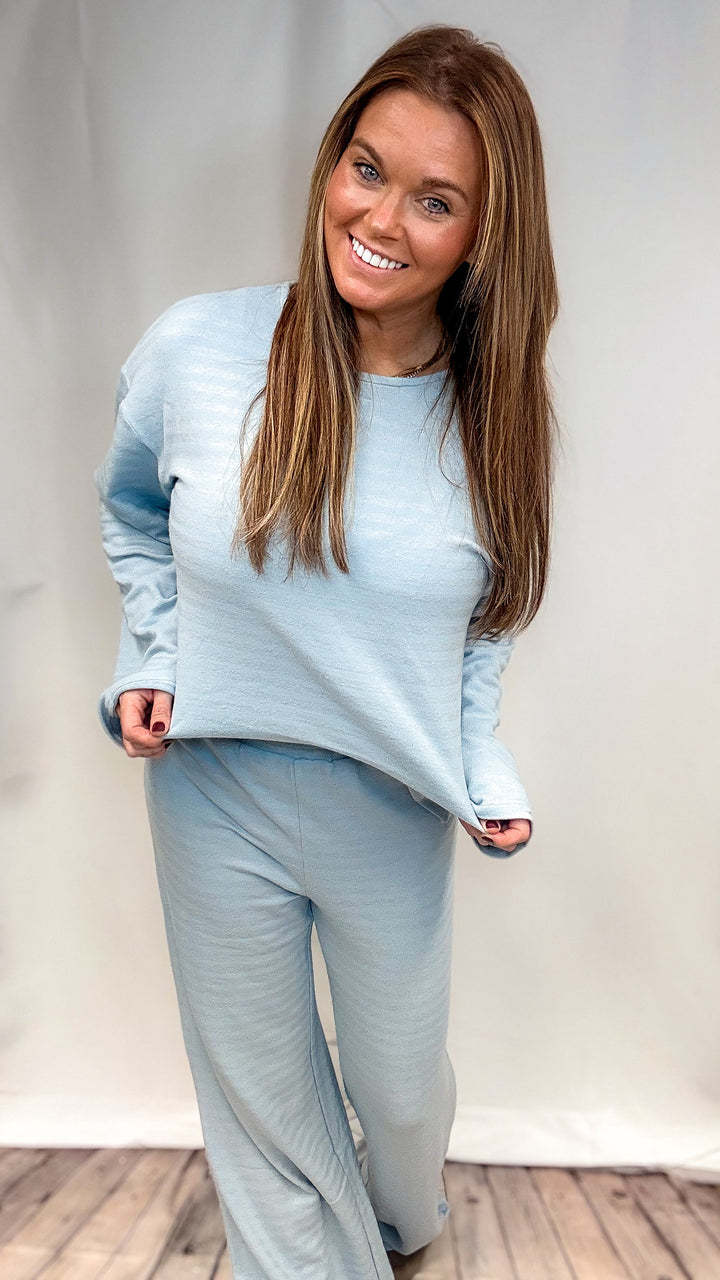 Woman wearing matching light blue set on plain background