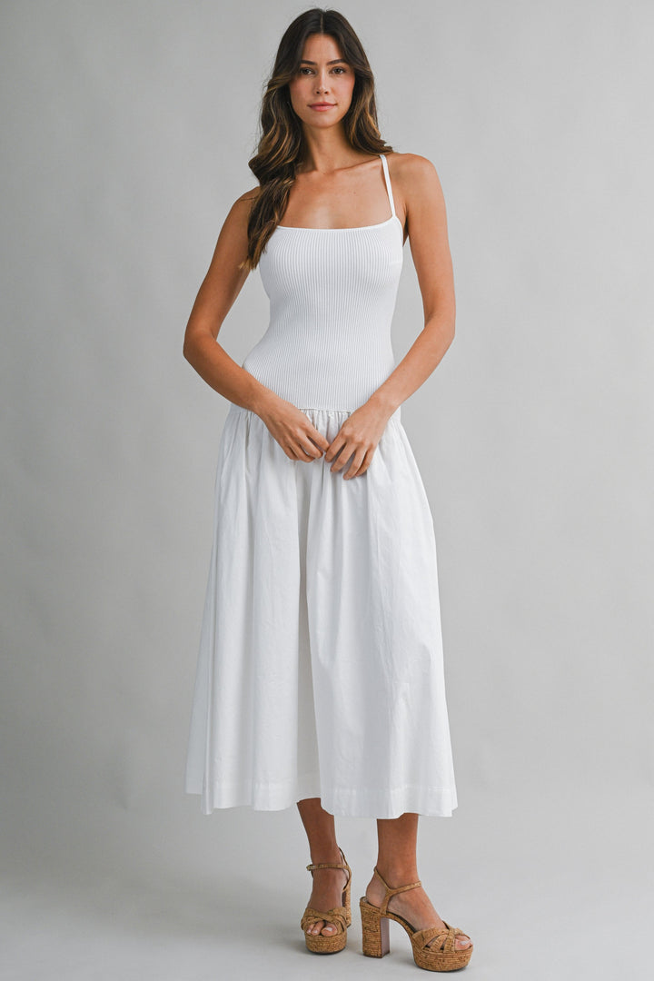 Woman wearing a white dress against a gray background
