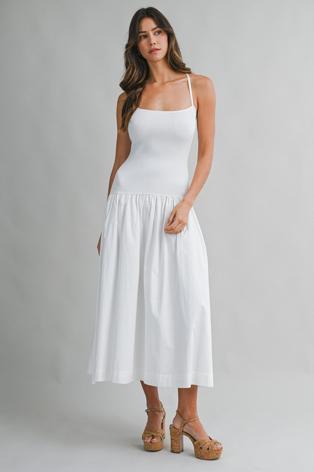 Woman wearing a white dress against a gray background