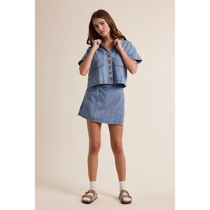 woman wearing denim wrap skort on plain background