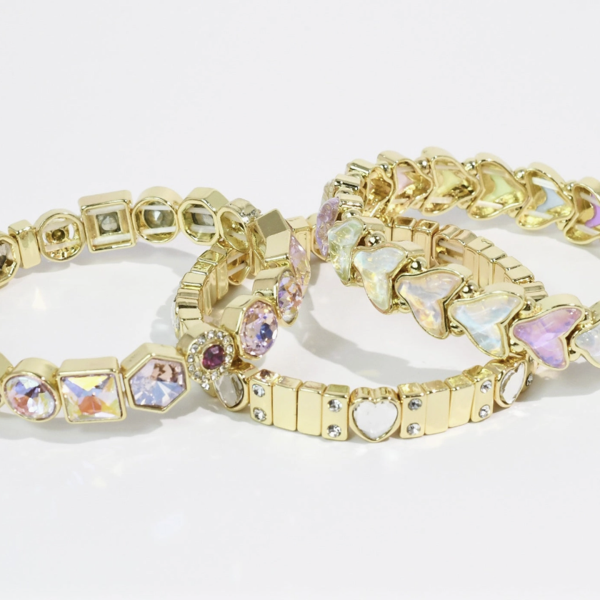 Gold bracelets with gemstone accents on a white background