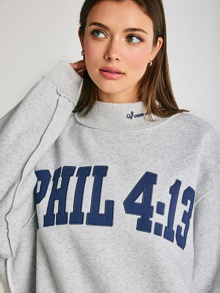 Person wearing a gray sweatshirt with 'PHIL 4:13' text