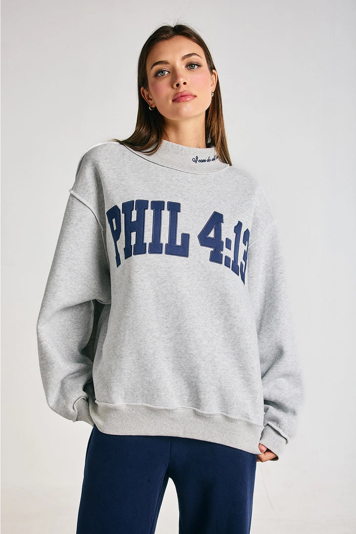 Woman wearing a gray sweatshirt with &
