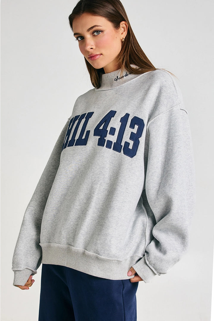Woman wearing a gray sweatshirt with &