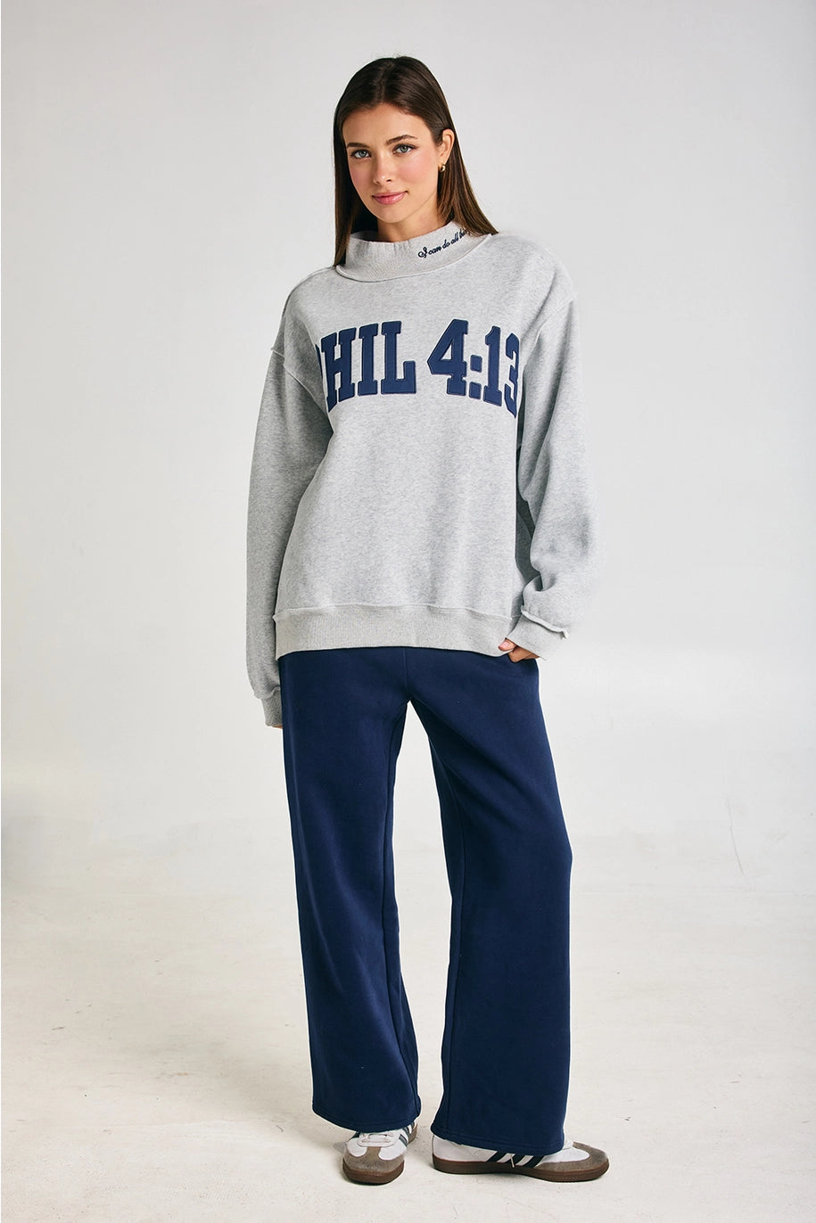Woman wearing a gray sweatshirt with &