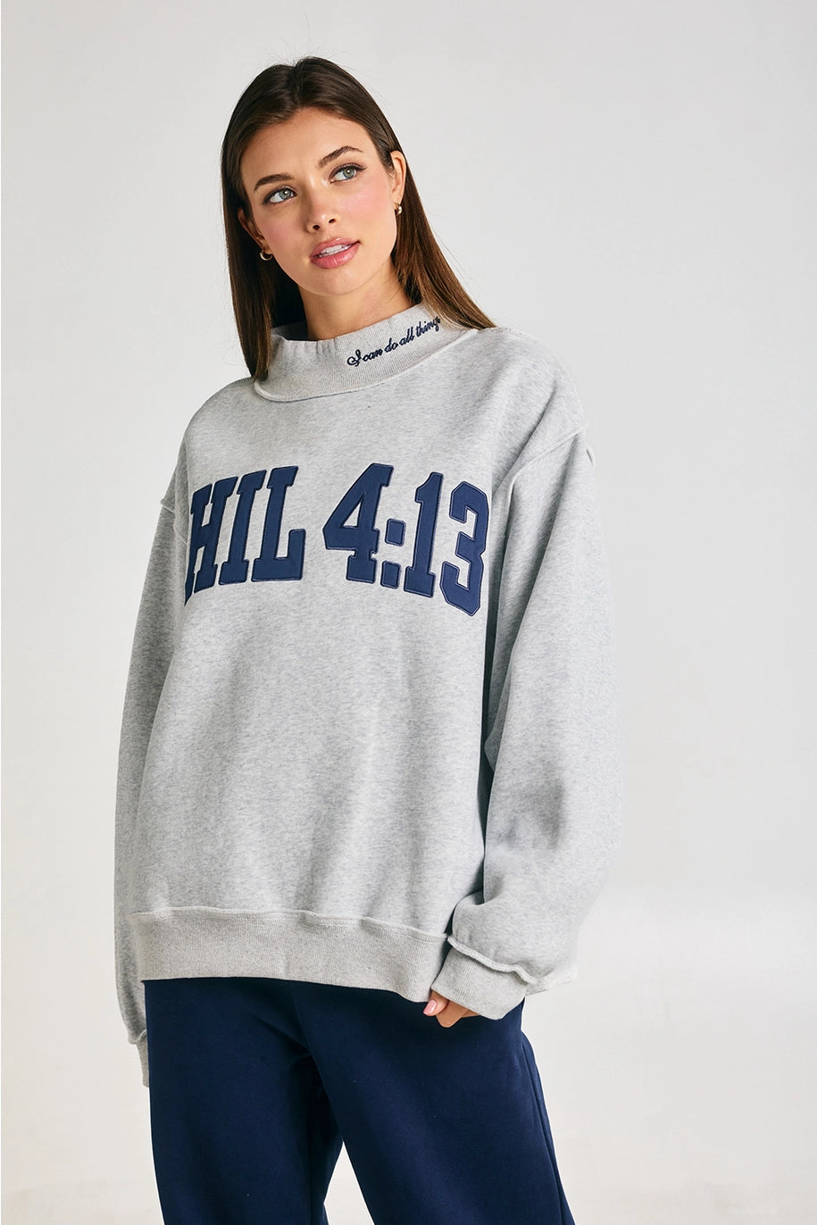 Woman wearing a gray sweatshirt with &