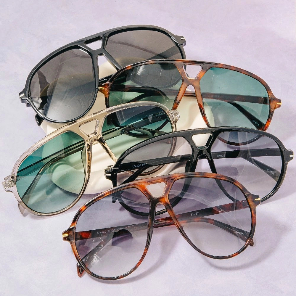 Collection of sunglasses with different frame colors and lens colors on a light gray background