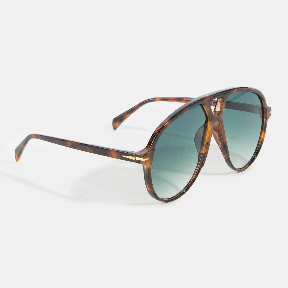 Sunglasses with tortoiseshell frame and green gradient lenses on a white background
