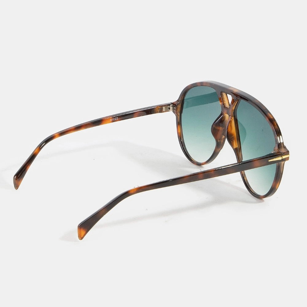 Sunglasses with tortoiseshell frame and green lenses on a white background