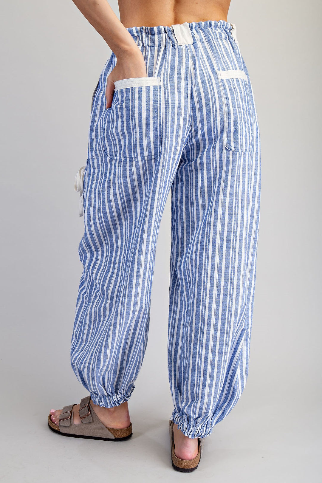 Woman wearing blue stripe pants on plain background