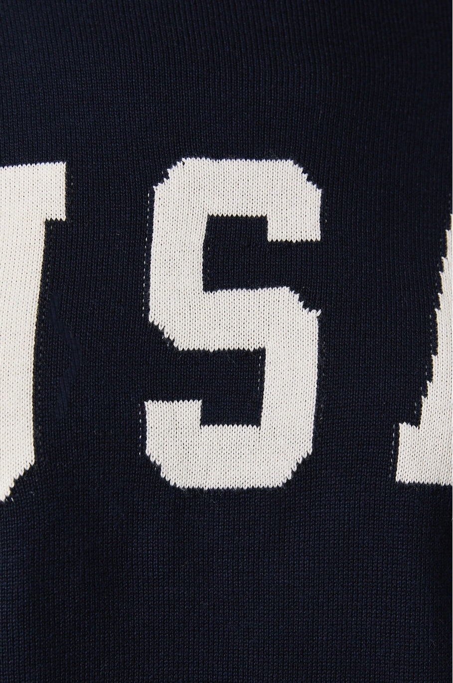 Close-up of a blue sweater with white text on a dark background