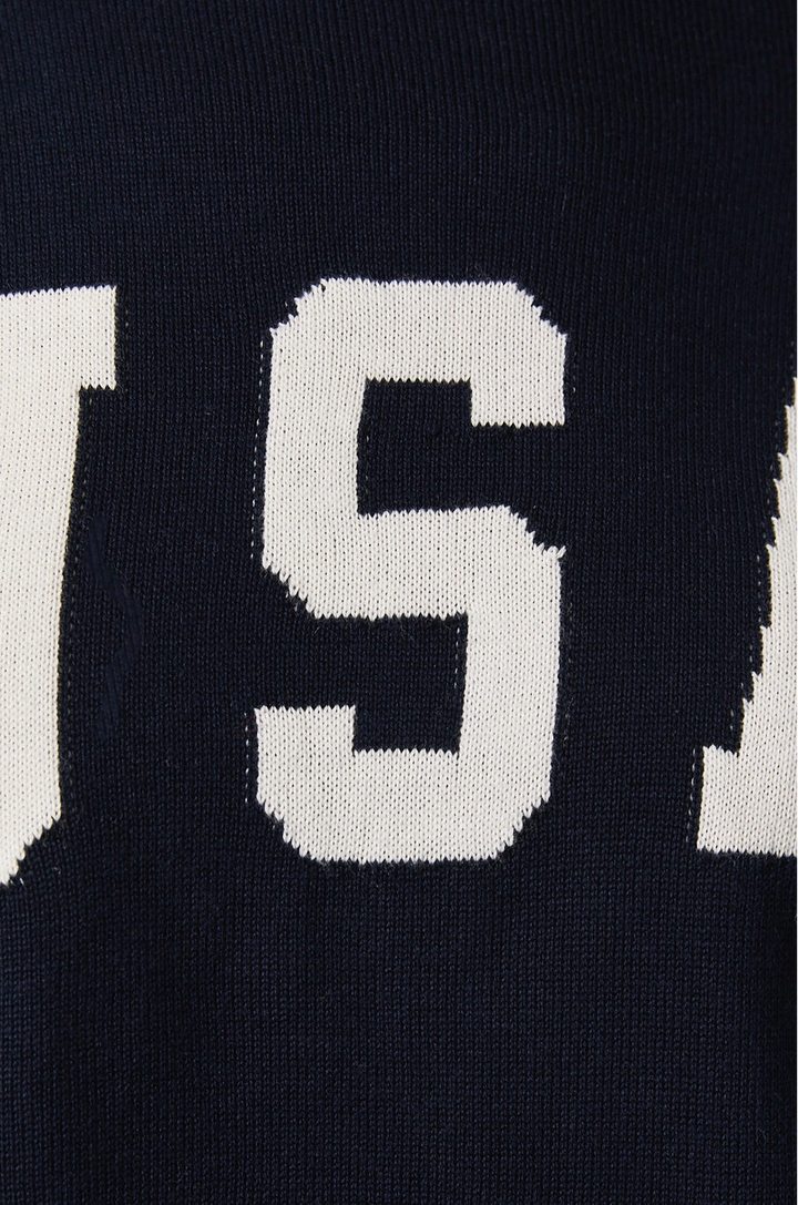 Close-up of a blue sweater with white text on a dark background