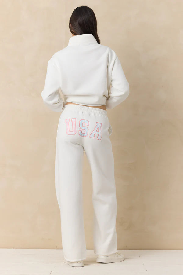 Person wearing a white tracksuit with &