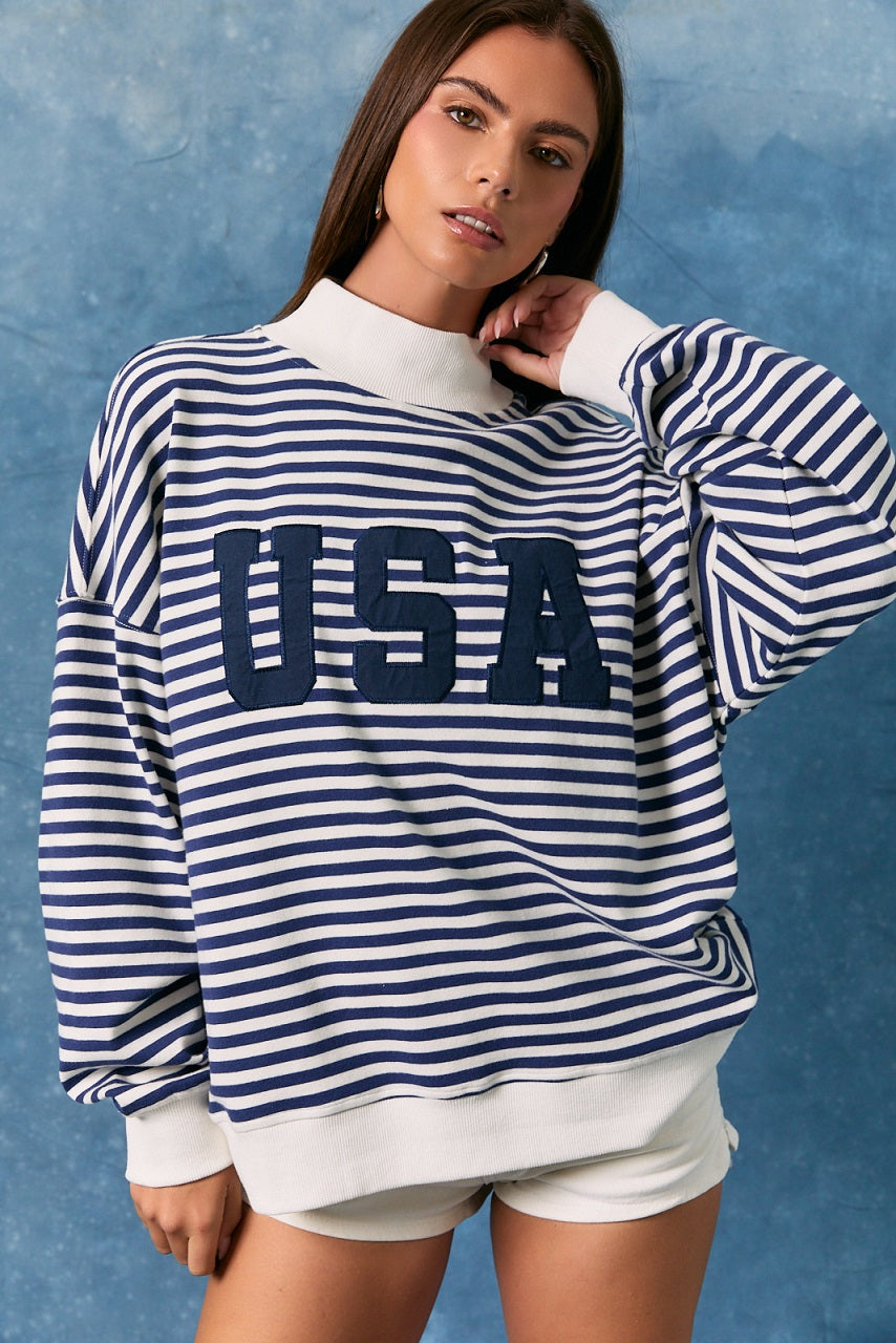 Woman wearing a blue and white striped sweatshirt with &