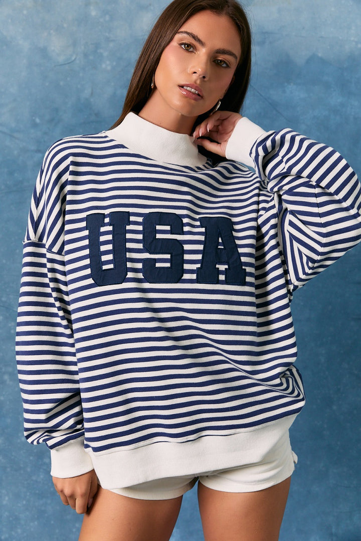 Woman wearing a blue and white striped sweatshirt with &