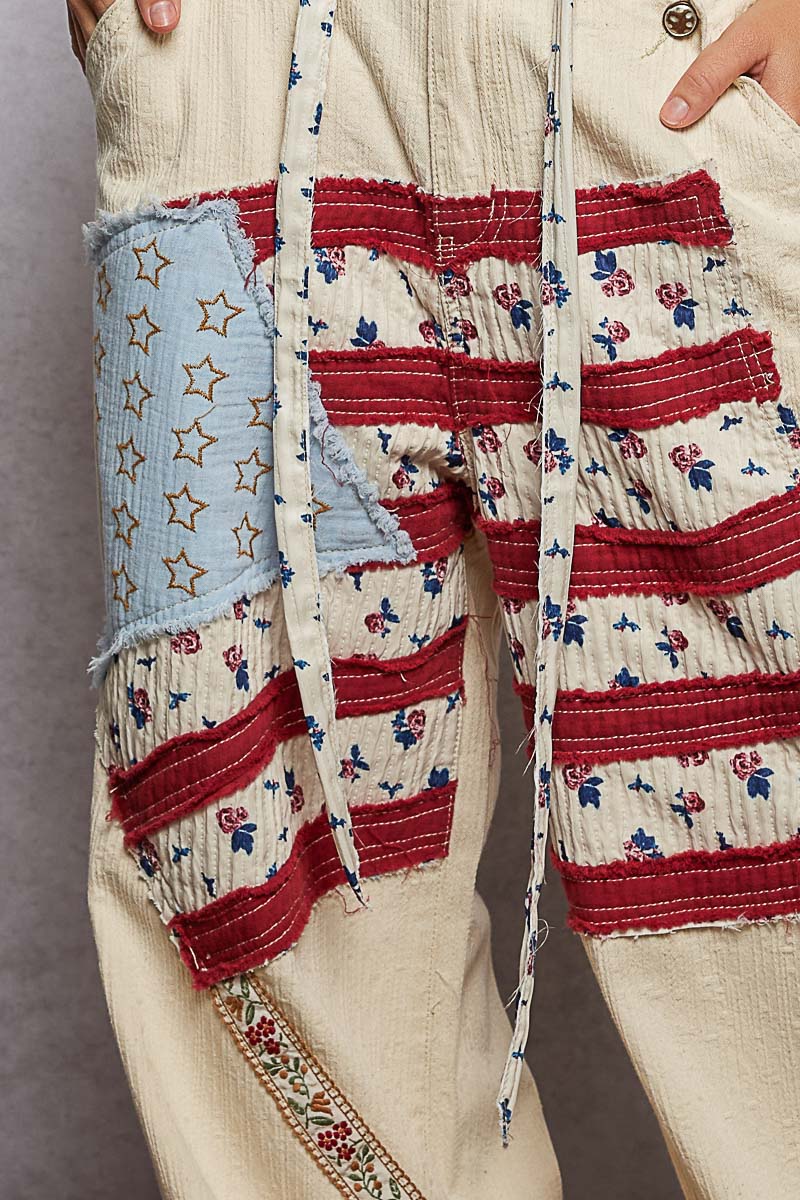 Patchwork pants with red, white, and blue patterns on a neutral background