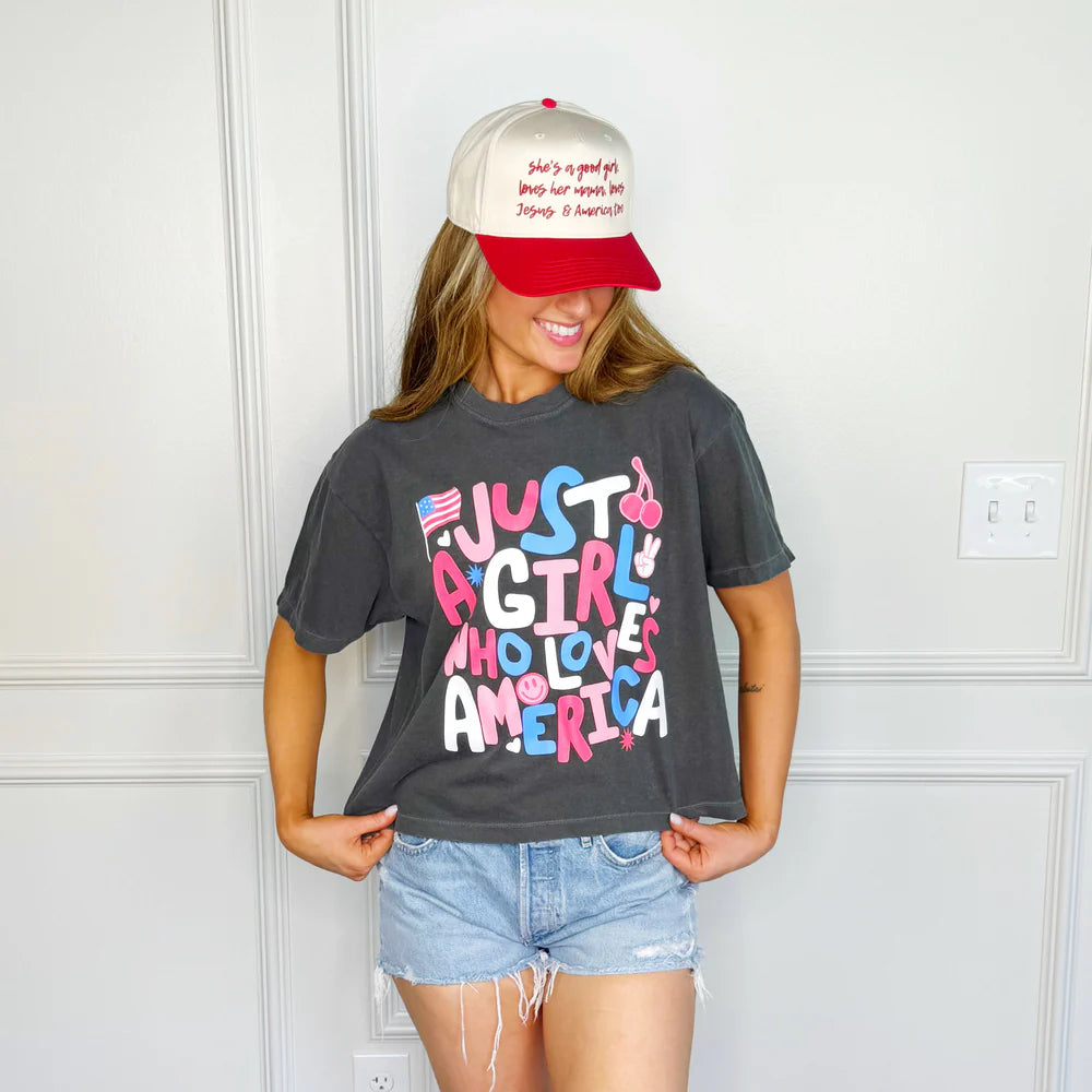 Woman wearing black graphic tee and jean shorts on white background
