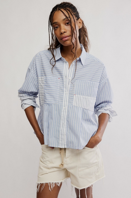 Woman wearing blue and white stripe button down shirt and khaki shorts on white background