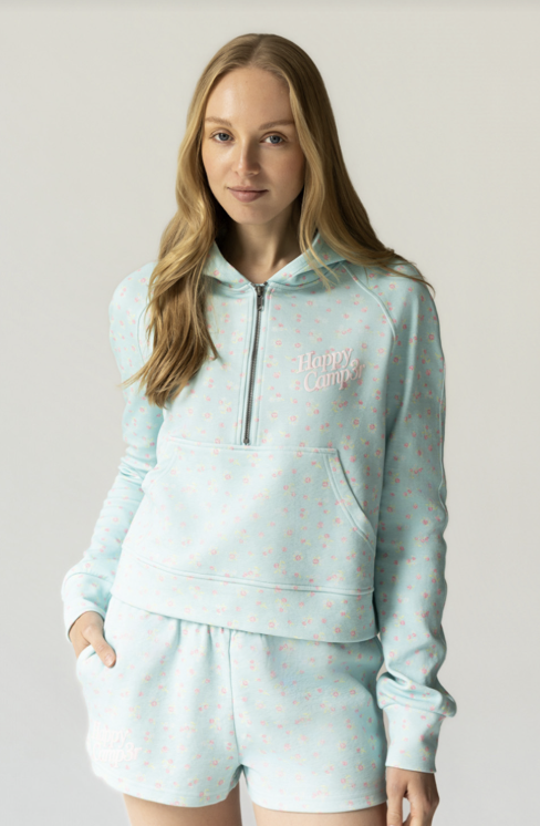 Woman wearing aqua graphic zip hoodie and shorts on white background