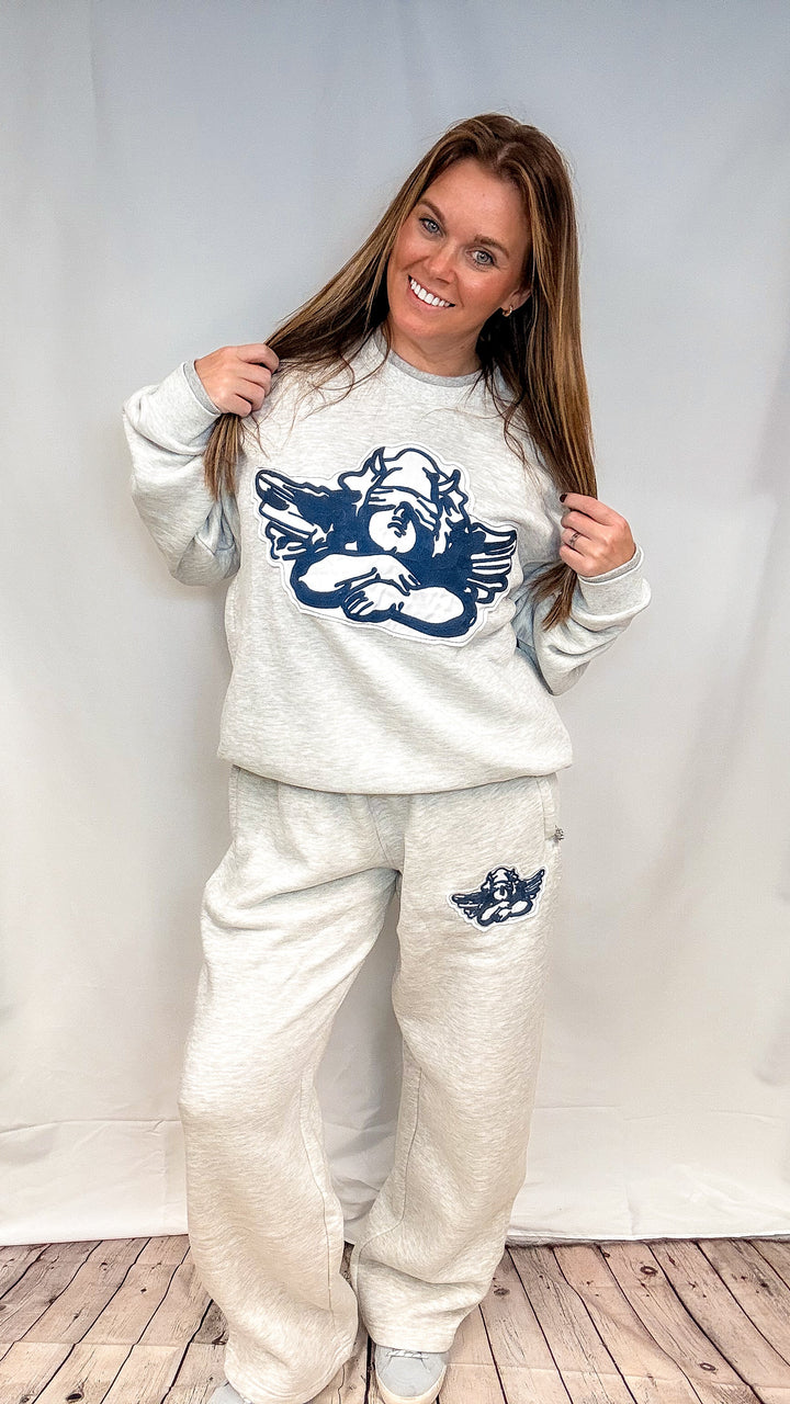 Woman wearing heather grey sweatsuit with cherub decal on white background