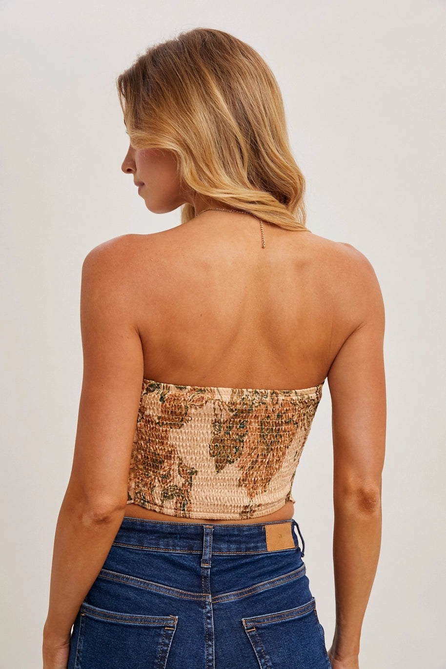 Back of woman wearing peach paisley print tube top on plain background