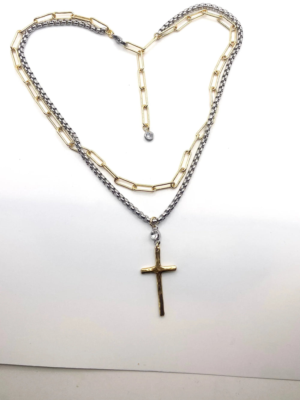 Necklace with a cross pendant shaped into a heart on a white background