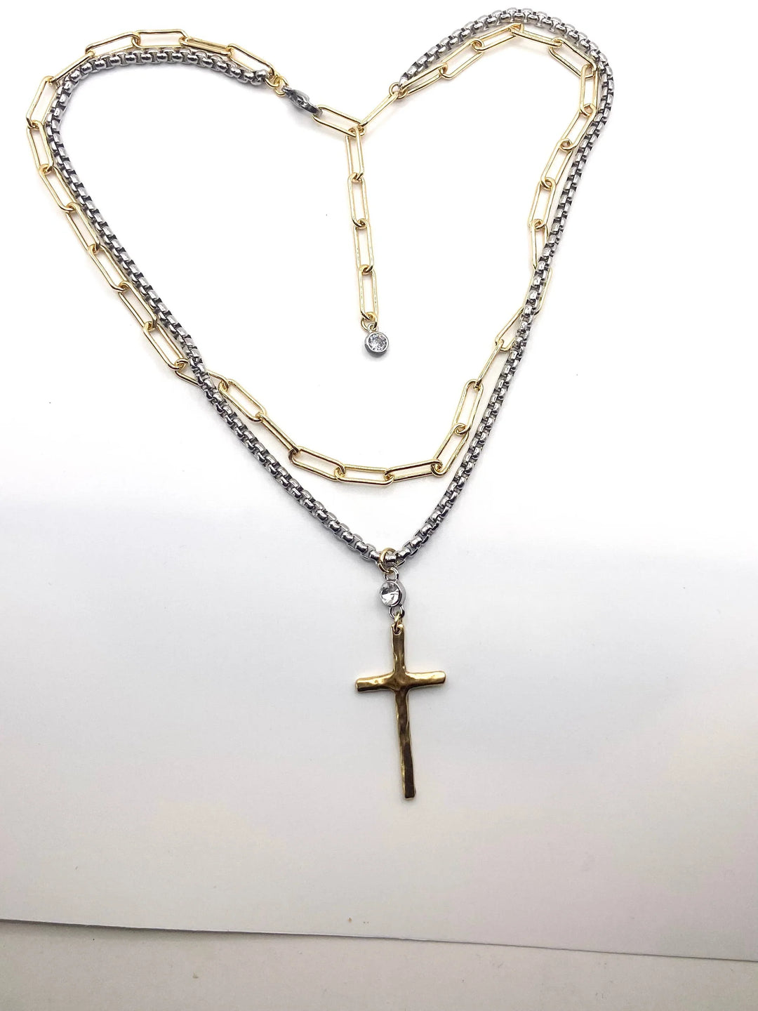 Necklace with a cross pendant shaped into a heart on a white background