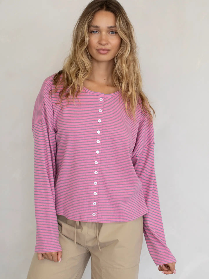 Woman wearing a pink striped shirt with a plain background