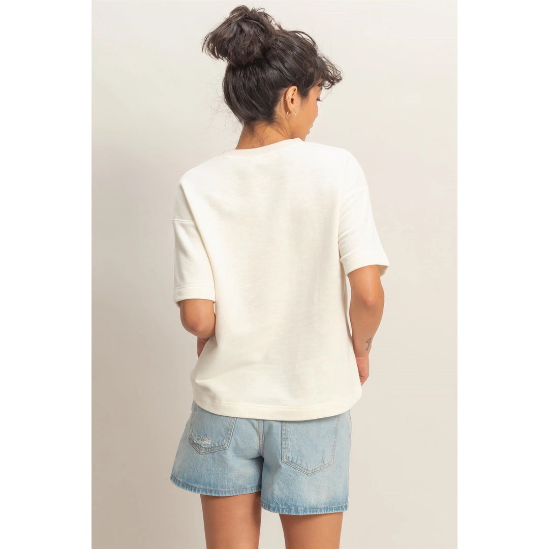 Person wearing a white t-shirt and denim shorts on a plain background