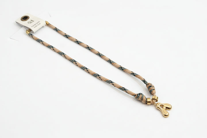 Cord necklace with gold bubble A on plain background