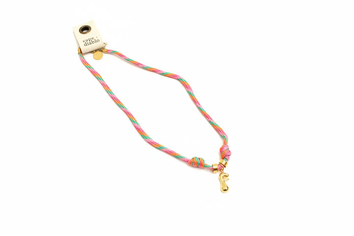 Cord necklace with gold bubble F on plain background