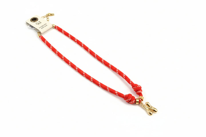 Cord necklace with gold bubble N on plain background
