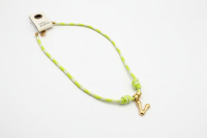 Cord necklace with gold bubble V on plain background