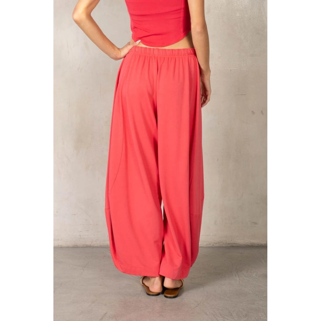 Back of woman wearing matching red set on plain background