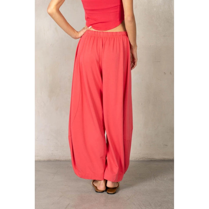 Back of woman wearing matching red set on plain background