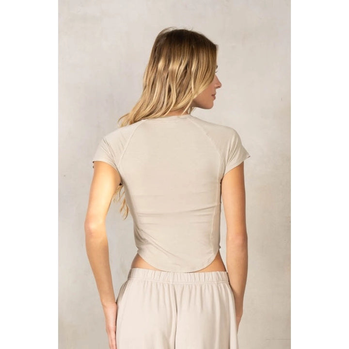 Back of woman wearing matching beige set on plain background