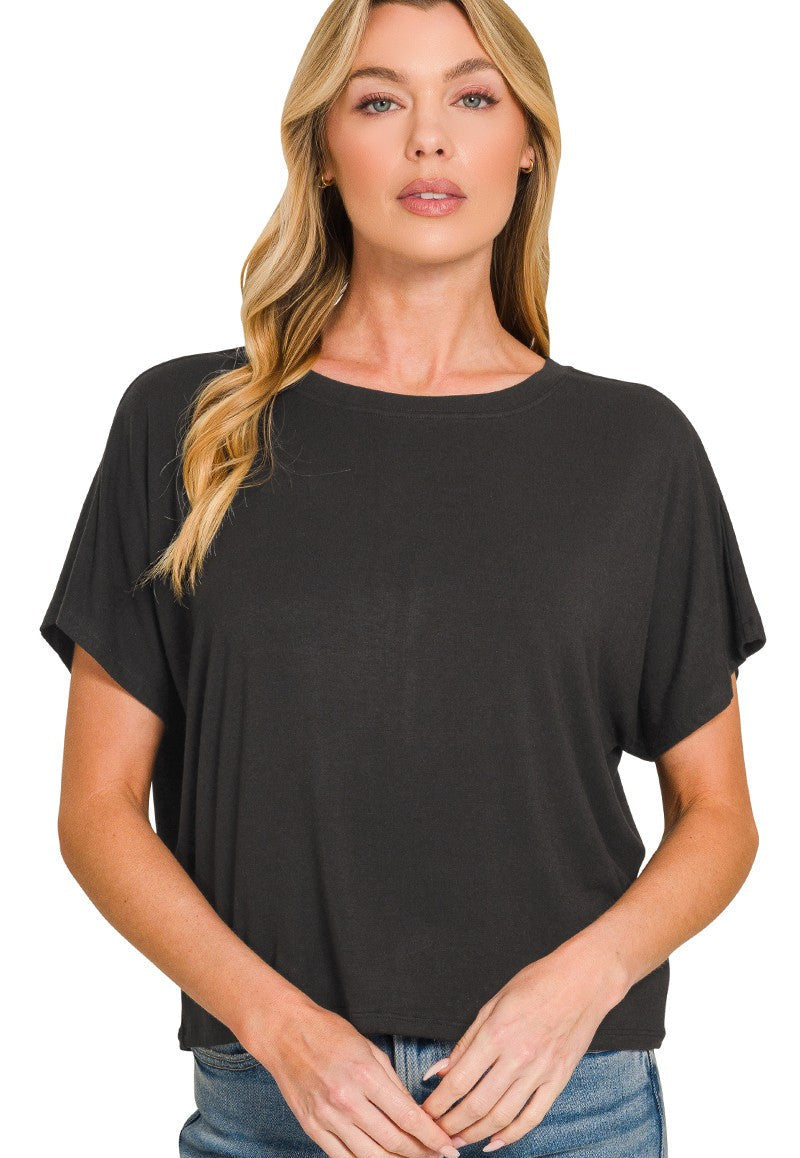 Woman wearing a black t-shirt and blue jeans on a white background
