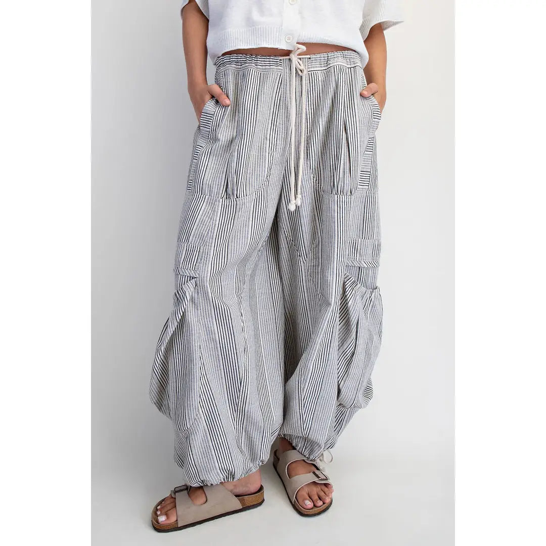 Person wearing striped wide-leg pants on a plain background