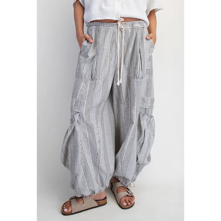 Person wearing striped wide-leg pants on a plain background
