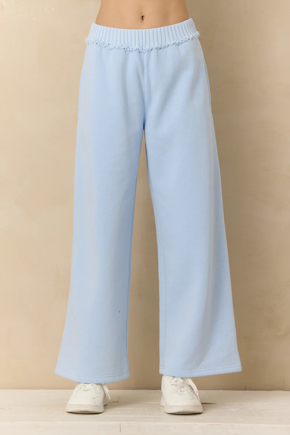 Light blue pants worn by a person on a beige background