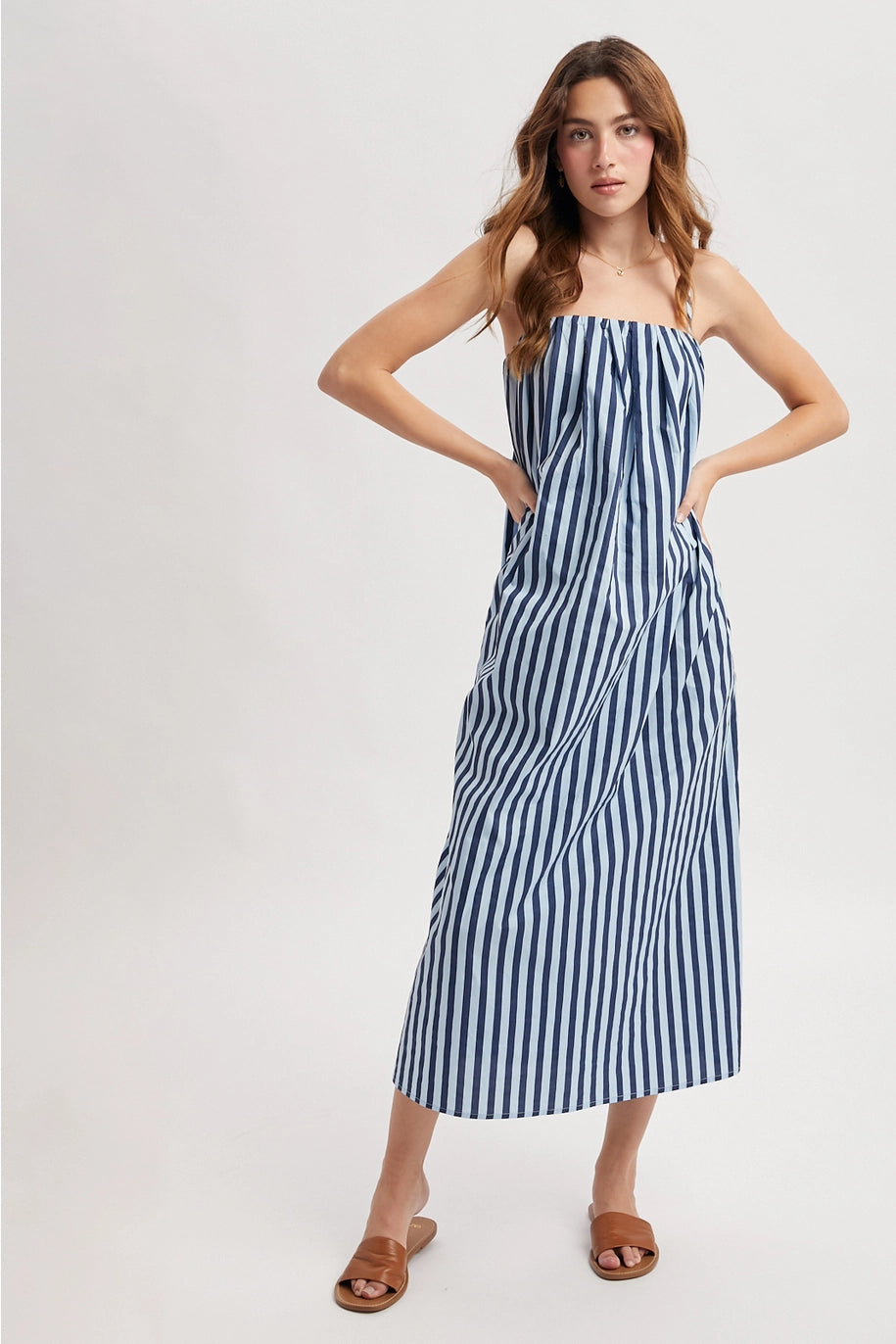 Woman wearing blue stripe dress on plain background