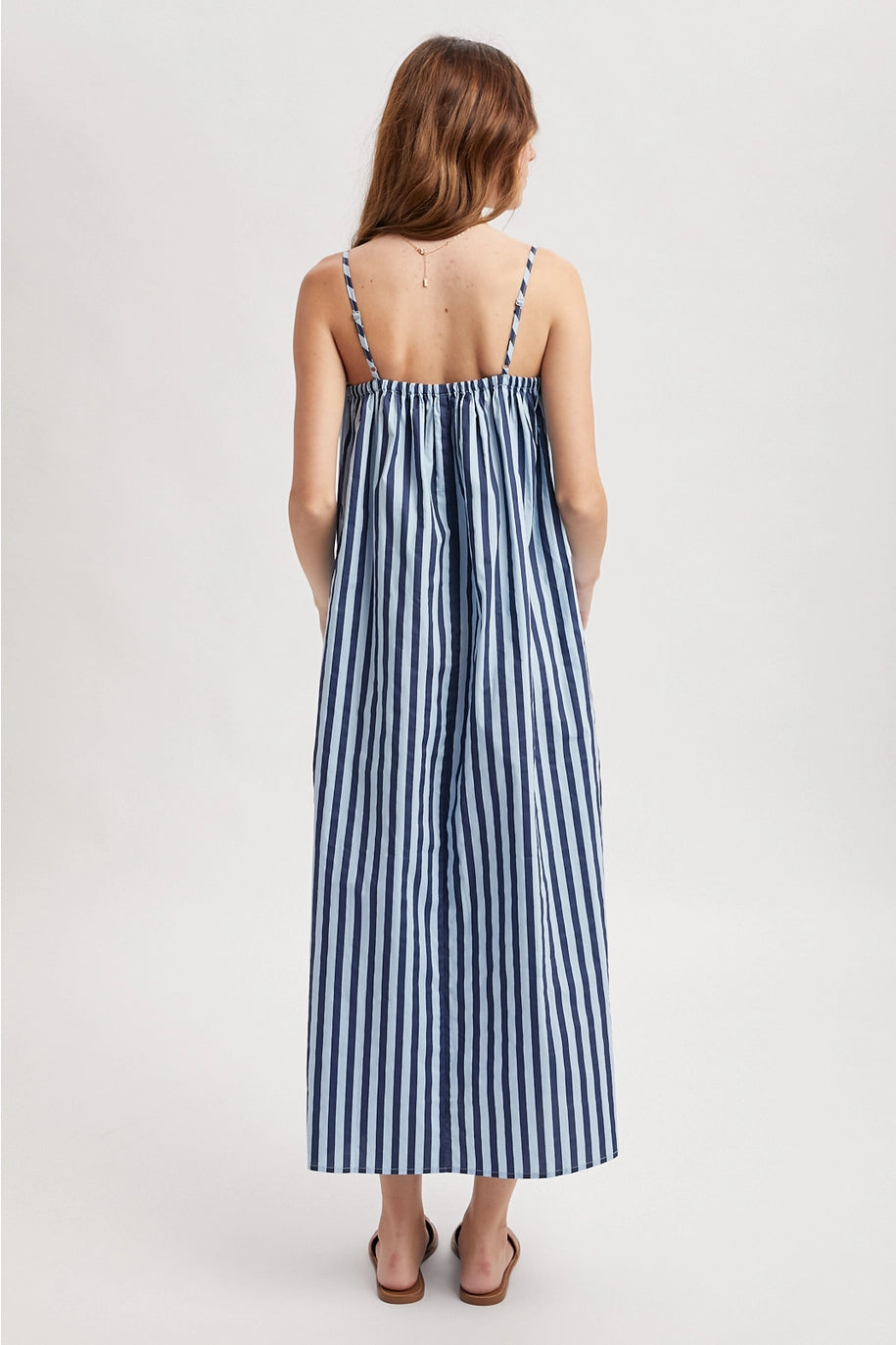 Woman wearing a blue and white striped dress on a white background